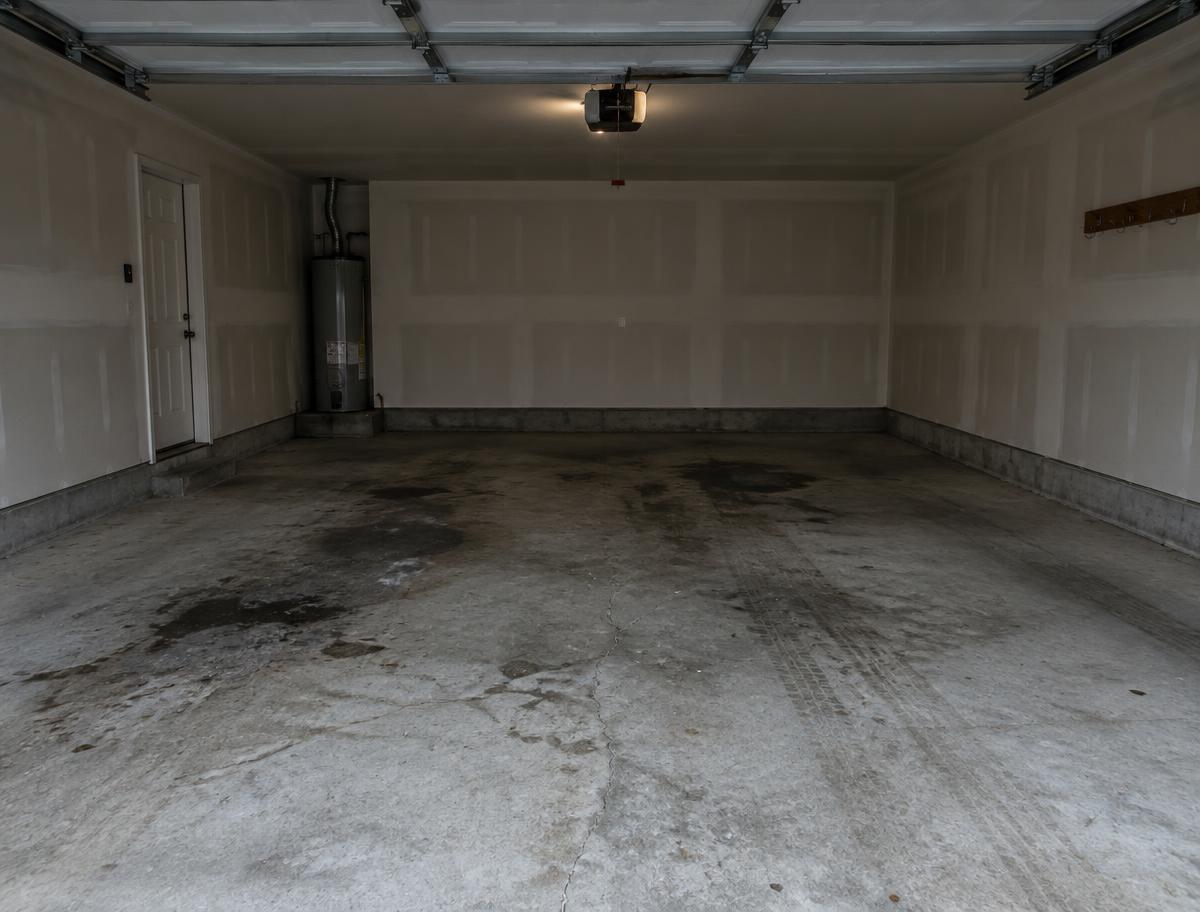 Bare, stained concrete garage floor before TUFFCOAT coating